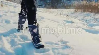 一个孩子在新鲜的雪上玩耍。 在图片中只能看到穿靴子的腿